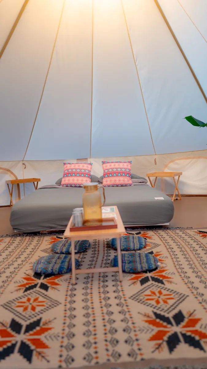 Ruang duduk dan katil di dalam bell tent