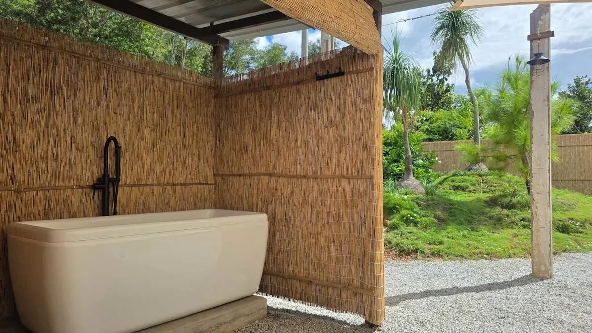 Tab mandi Superior Villa di ruang terbuka dengan dinding buluh